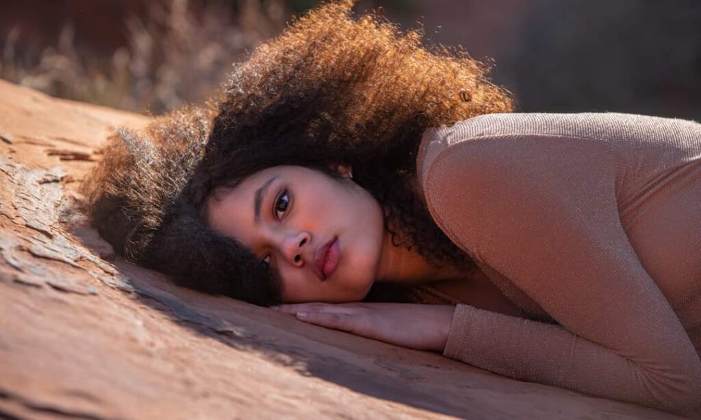 young girl laying on a rock for photoshoot